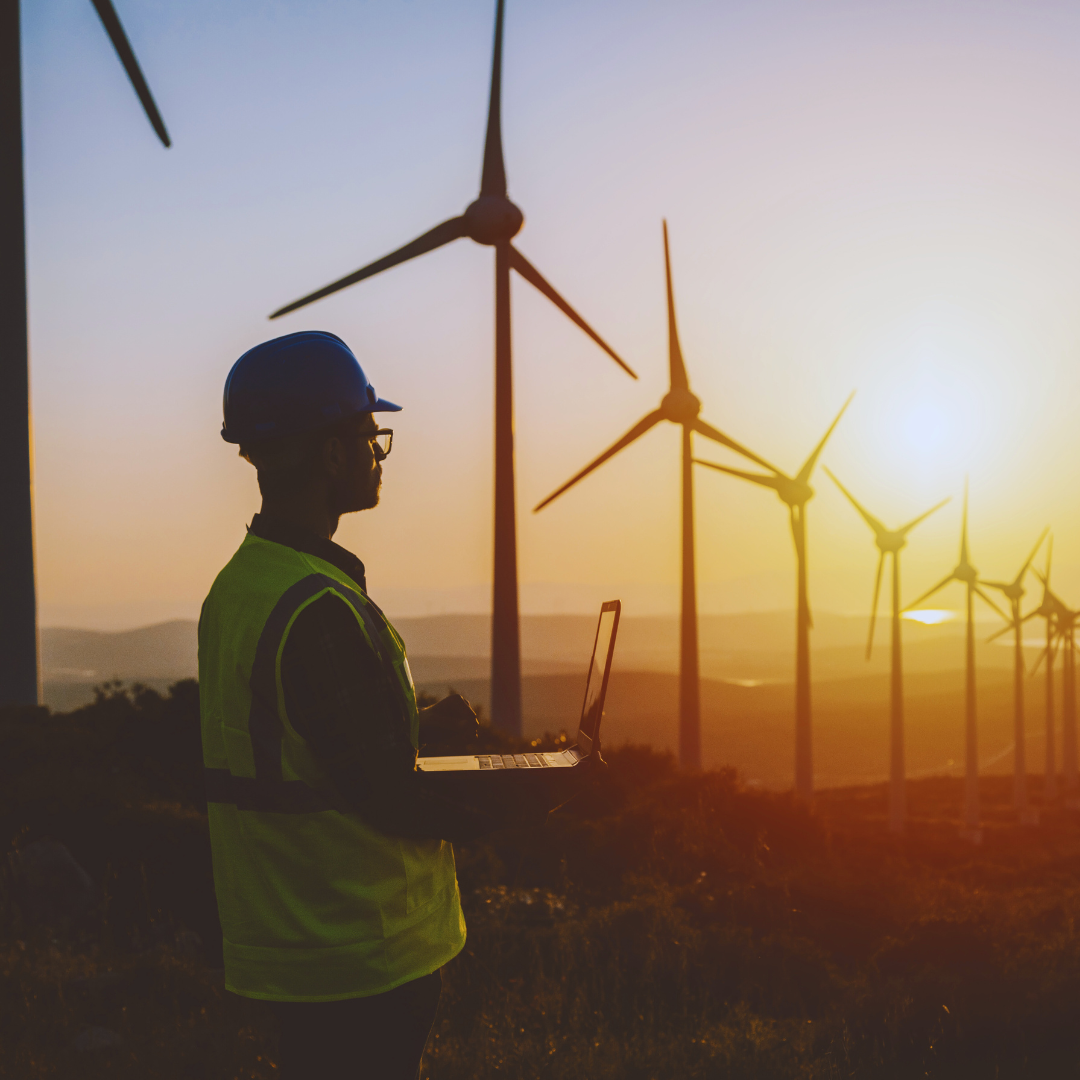 Auzvolt engineer working at a wind farm during sunset